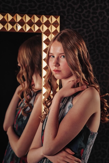Portret całkiem ładna nastolatka w eleganckiej sukience w lustrze