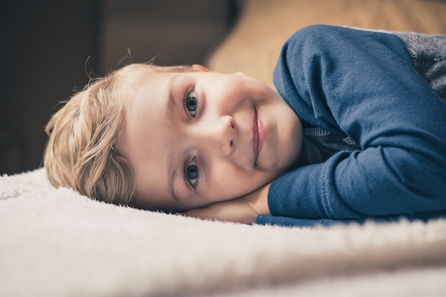 Portret chłopca leżącego w łóżku w domu