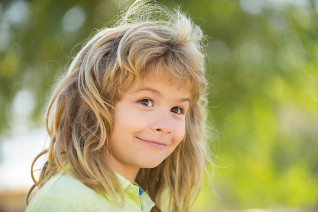 Portret chłopca na zielonym tle park w naturze Wow look Portret zdumiony ładny mały chłopiec z kręconymi włosami zaskoczony przedszkolak Piękne dziecko z letnim parkiem na zewnątrz