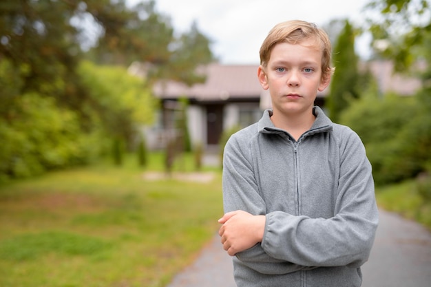 Zdjęcie portret chłopca stojącego na zewnątrz