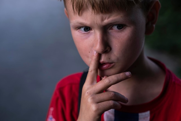 Portret chłopca szczącego nosem Myślny chłopiec zmarszcza czoła