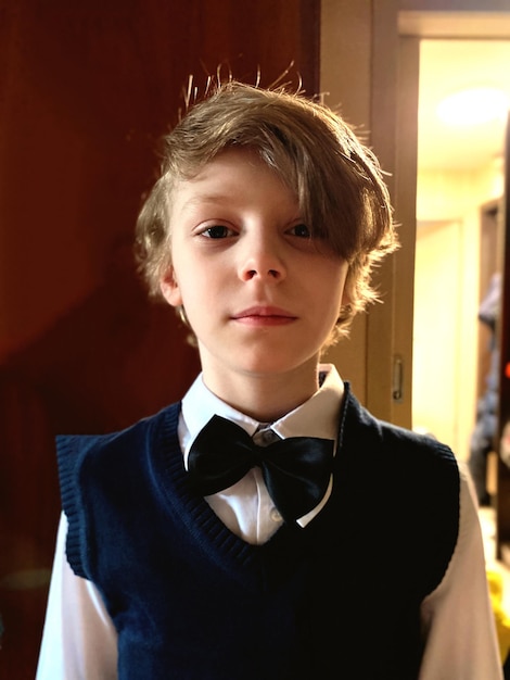 Zdjęcie portret chłopca w mundurze stojącego w domu