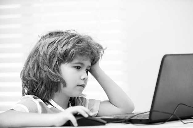 Portret chłopca w szkole patrzącego na laptopa podczas lekcji Edukacja i nauka dla dziecka