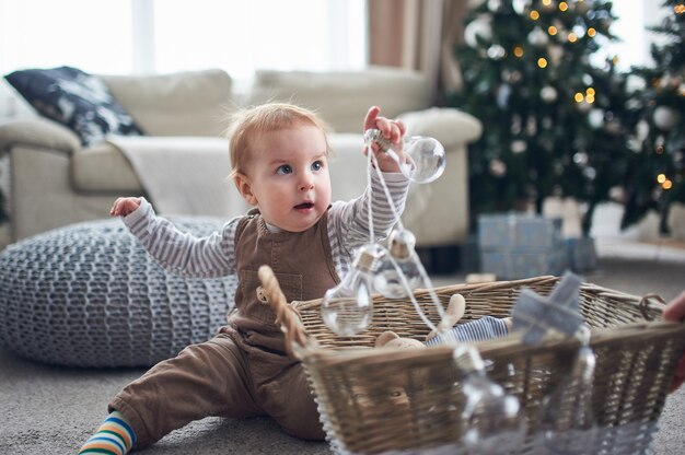 Portret cute 1-letniego chłopca siedzącego na podłodze.