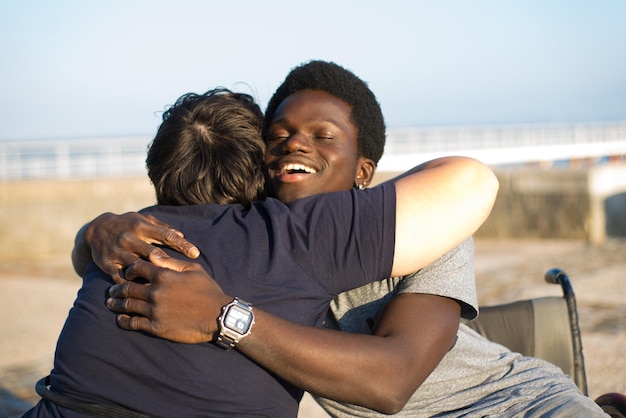 Portret delikatnej rodziny biracial na romantyczną randkę w parku. African American człowieka i Kaukaski kobieta na wózkach inwalidzkich, przytulanie. Koncepcja miłości, uczucia, szczęścia