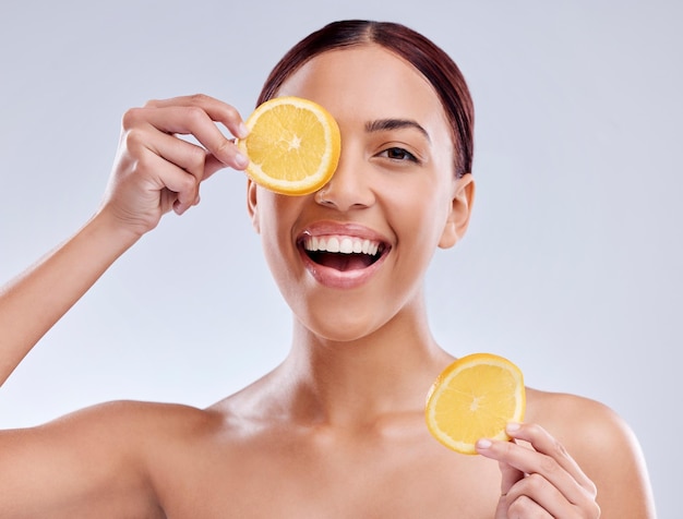 Portret do pielęgnacji skóry lub szczęśliwa kobieta z pomarańczową lub naturalną twarzą z cytrusami lub witaminą c dla odnowy biologicznej Uśmiech w tle Studio lub zdrowa dziewczyna uśmiechająca się z organicznymi owocami dla urody dermatologicznej