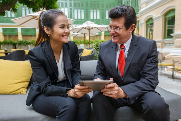 Portret dojrzałego biznesmena i młodych bizneswoman azjatyckiego razem jako koncepcja różnorodności zespołu w kawiarni