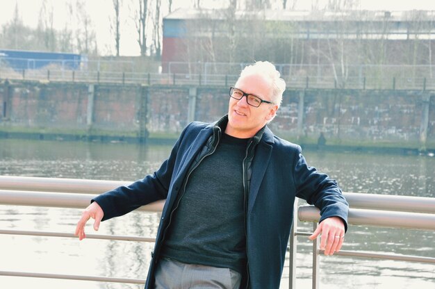 Portret dojrzałego mężczyzny na poręczy przy jeziorze