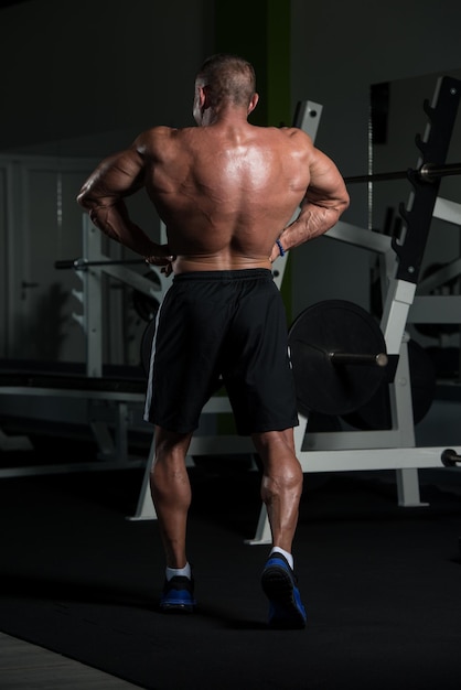 Portret dojrzałego, sprawnego fizycznie mężczyzny, pokazującego swoje dobrze wyszkolone ciało. Mięśni atletyczny kulturysta Fitness mężczyzna pozuje po ćwiczeniach