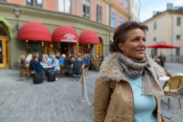 Zdjęcie portret dojrzałej pięknej skandynawskiej turystki z krótkimi włosami podróżującej po sztokholmie w szwecji