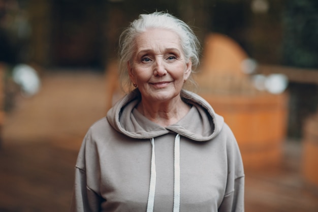 Portret dojrzałej siwej starej kobiety na zewnątrz