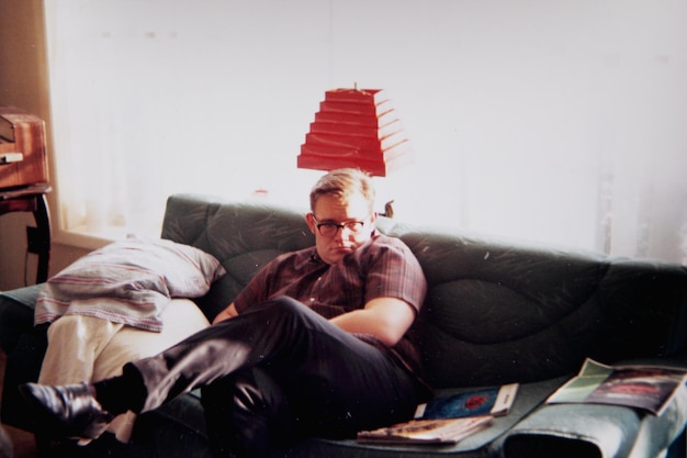Portret dorosłego mężczyzny siedzącego w domu na kanapie