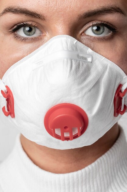 Portret dorosłej kobiety jest ubranym chirurgicznie maskę