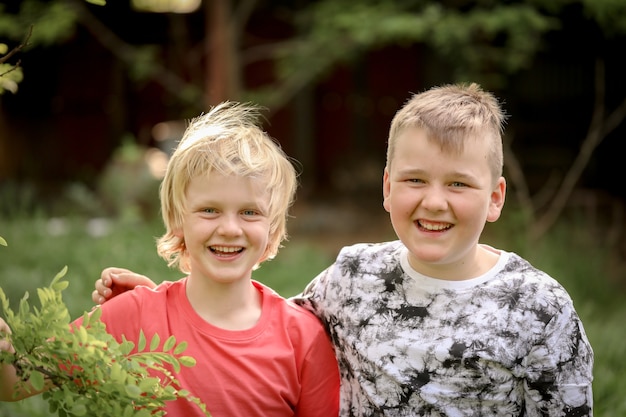 Portret dwóch blond braci uśmiechających się szeroko do kamery
