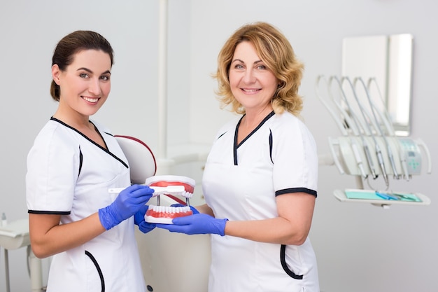Zdjęcie portret dwóch dentystek pozujących w nowoczesnej klinice dentystycznej