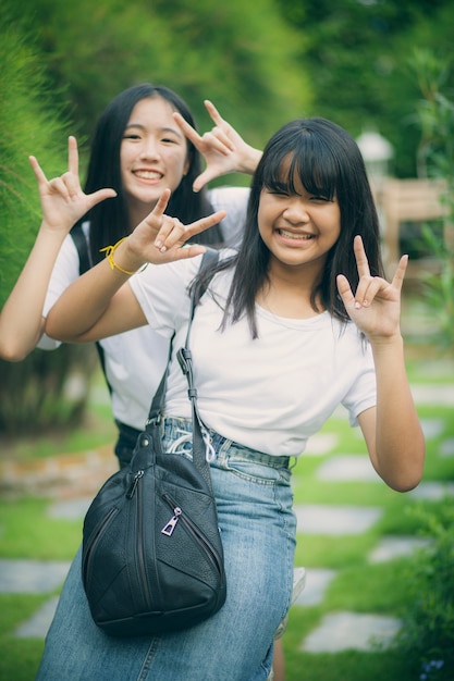 Portret dwóch nastolatek azjatyckich relaks ze szczęściem w zielonym parku