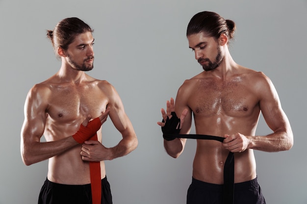 Portret dwóch sportowych, muskularnych, bez koszuli braci bliźniaków