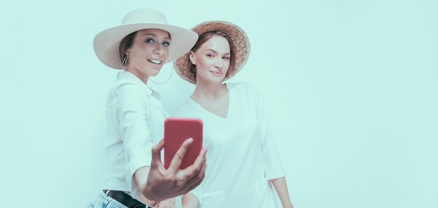 Portret dwóch uśmiechniętych kobiet przy selfie. Koncepcja podróży. Różne środki przekazu