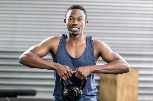 Portret dysponowanego mężczyzna podnośni dumbbells przy gym