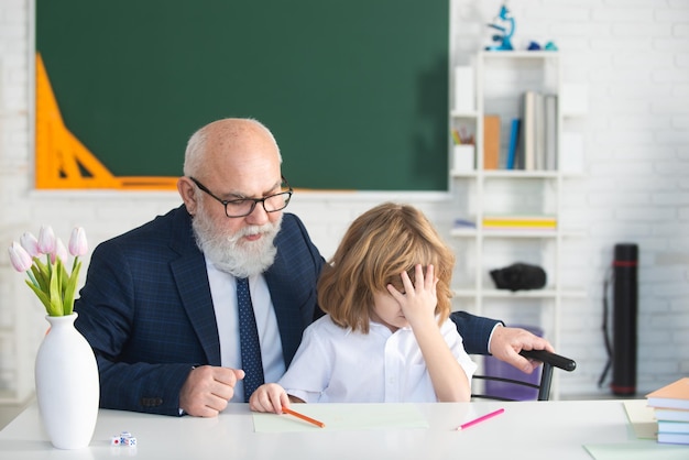 Zdjęcie portret dziadka i smutnego wnuka ucznia ucznia z problemem w klasie w szkole