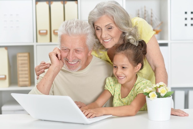 Portret dziadków z wnuczką za pomocą laptopa