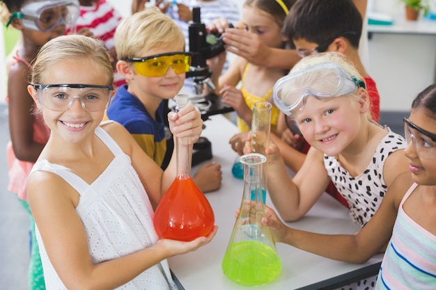 Zdjęcie portret dzieciaki trzyma laborancką kolbę w laboratorium