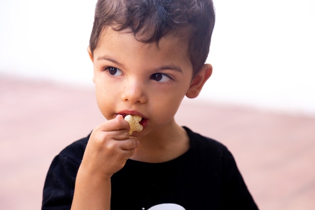 Portret Dziecka Jedzącego Chipsy Ziemniaczane Z Nieobecnym Wyrazem Twarzy, Patrząc W Bok