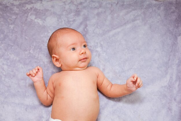 Portret dziecka w wieku 2-3 miesięcy na szarym tle, widok z góry