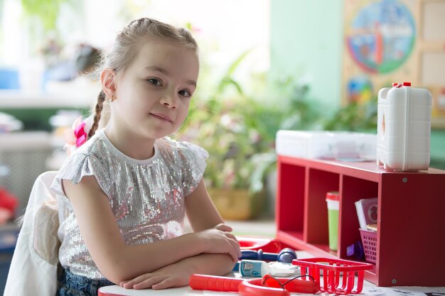 Portret dziecka w wieku przedszkolnym przy stole z zabawkami