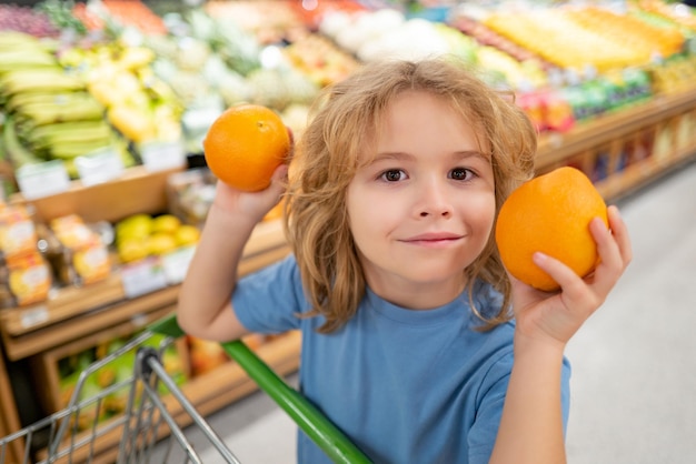 Portret dziecka z koszykiem zakupów żywności w sklepie spożywczym śmieszne dzieciaki stawiają czoła sprzedażom i sh