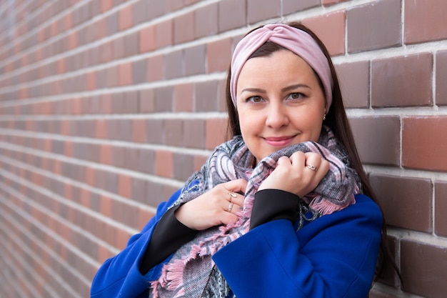 Zdjęcie portret dziewczynki brunetka w niebieskim płaszczu