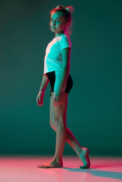 Portret Dziewczynki Gimnastyczka Rytmiczna Pozuje Na Białym Tle Na Zielonym Tle Studia W świetle Neonowym