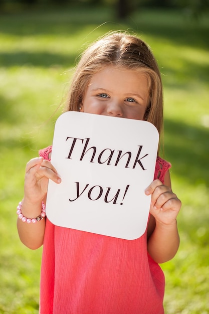 Portret dziewczynki trzymającej znak „Dziękuję”