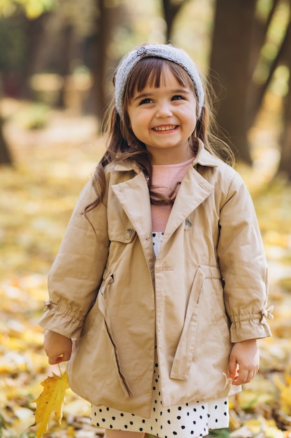 portret dziewczynki w beżowym płaszczu spacery w jesiennym parku