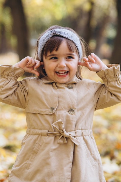 portret dziewczynki w beżowym płaszczu spacery w jesiennym parku