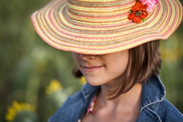 Zdjęcie portret dziewczynki w kapeluszu na blured naturalnym tle