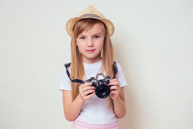 Portret dziewczynki z aparatem. Obraz słodkie dziewczyny w fotograf turystyczny słomkowy kapelusz.