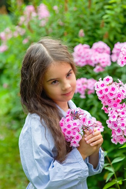 Zdjęcie portret dziewczynki z różowymi kwiatami phlox