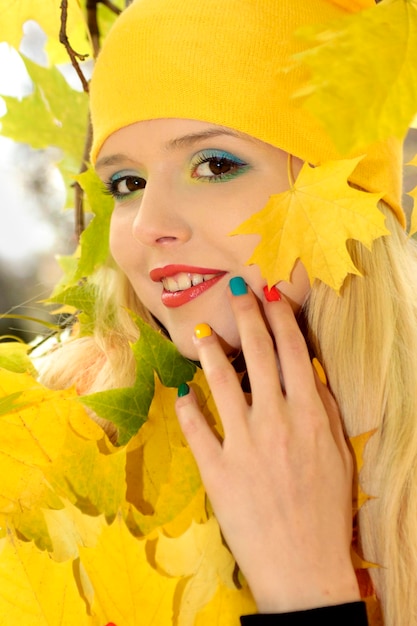 Portret dziewczynki z wielobarwnym manicure i makijażem jesienią.