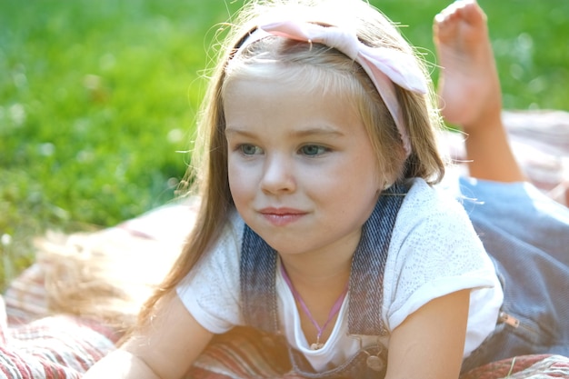 Portret dziewczyny ładne dziecko odpoczynek na świeżym powietrzu w parku latem.