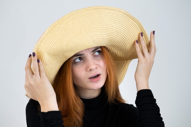 Portret dziewczyny rude w słomkowym kapeluszu.