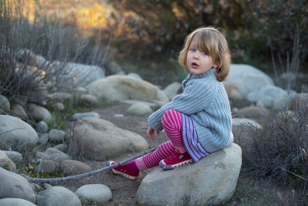 Zdjęcie portret dziewczyny siedzącej na skale