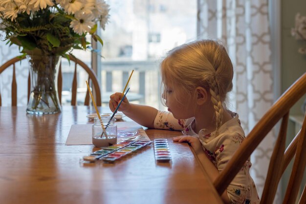 Zdjęcie portret dziewczyny siedzącej na stole w domu