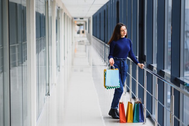 Portret dziewczyny stojącej w centrum handlowym po zrobieniu zakupów