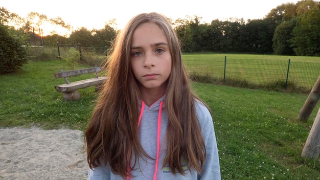 Zdjęcie portret dziewczyny z długimi włosami stojącej na polu