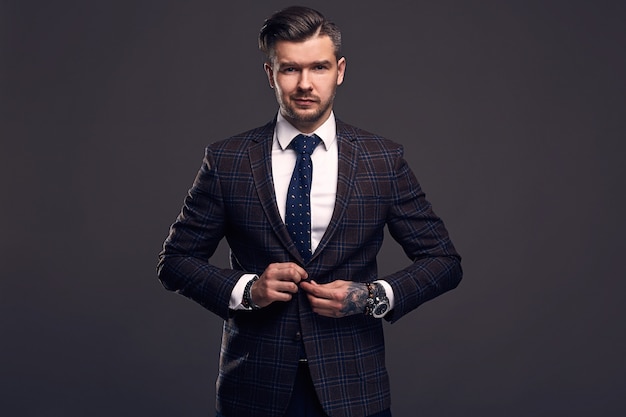 Portret eleganckiego brutalnego mężczyzny w wełnianym garniturze