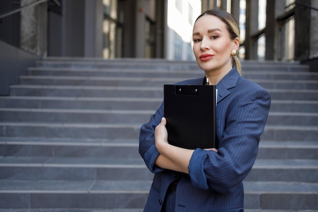 Portret eleganckiej kobiety biznesu ze schowkiem