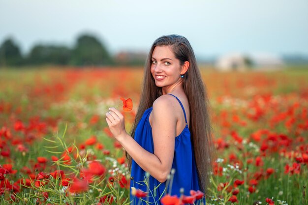 Portret Eleganckiej Młodej Kobiety Z Długimi Włosami W Polu Maku W Wieczornym Słońcu