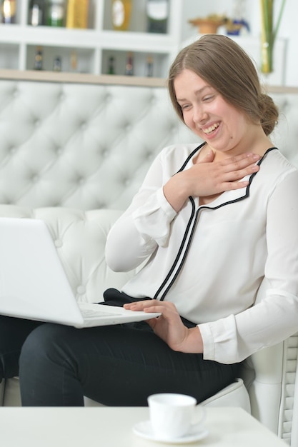 Portret emocjonalnej nastoletniej dziewczyny używającej laptopa