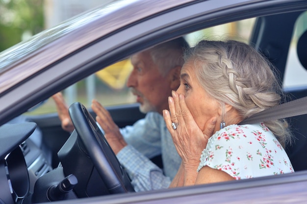 Portret emocjonalnej pary seniorów prowadzącej samochód